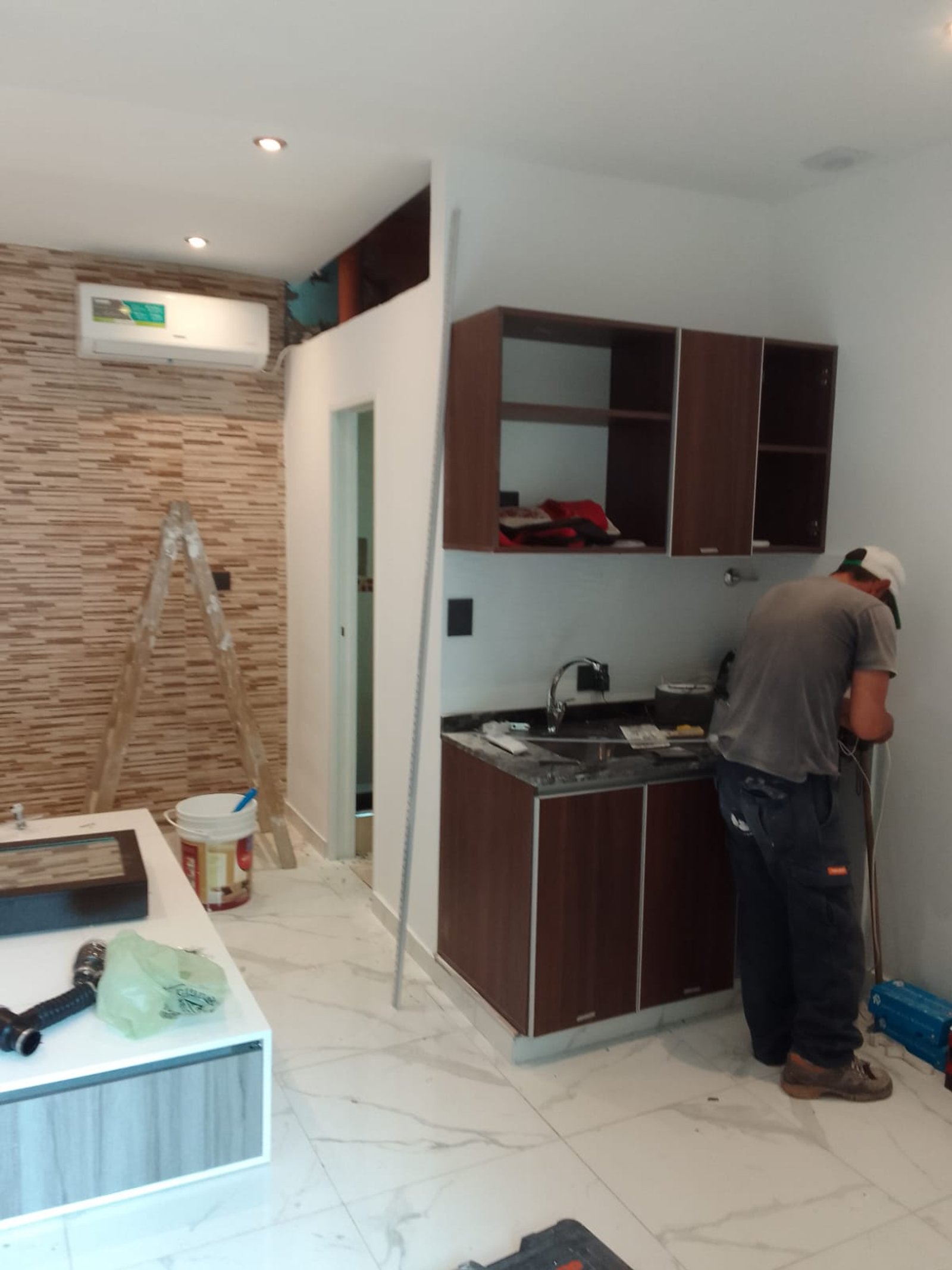 Cocina moderna en construcción con ladrillos y madera oscura — proyecto Departamentos para turistas en Barracas, por Arquitecto Guido Niccoli, en Barracas